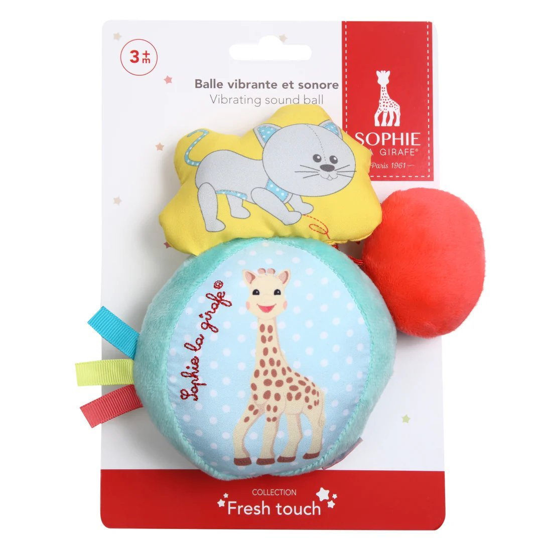 Vibrating sound toy ball in retail packaging, with giraffe print and red fabric pom