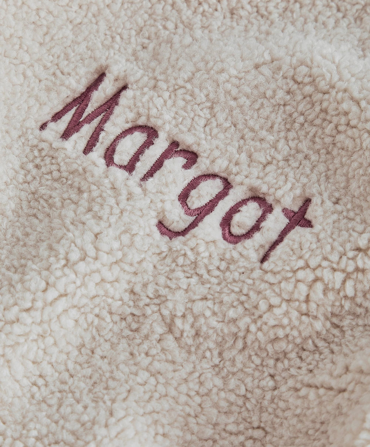 Cream borg fabric with embroidered word in burgundy thread