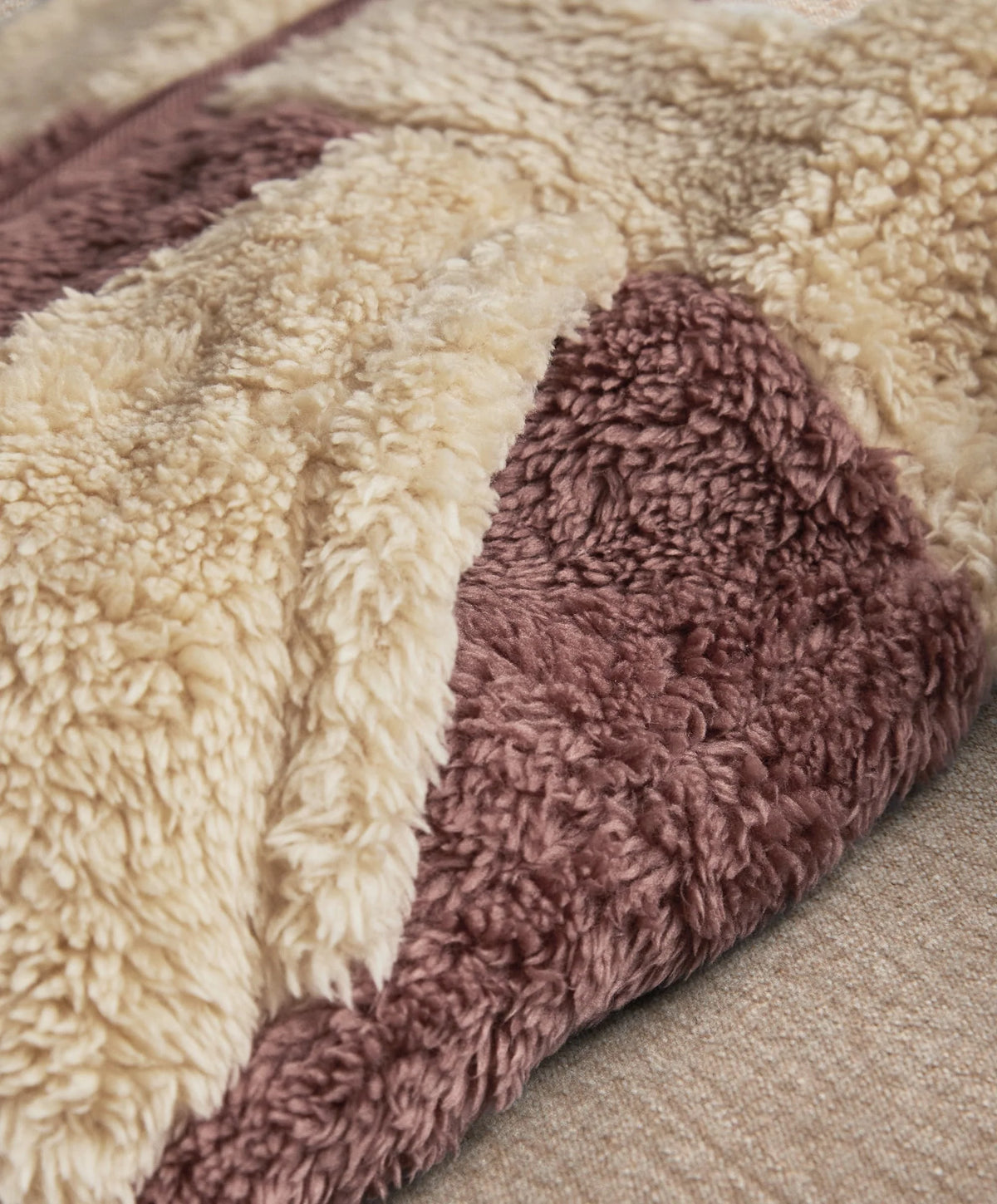 Color-block pramsuit fleece panel close-up, cream and dark plum plush pile