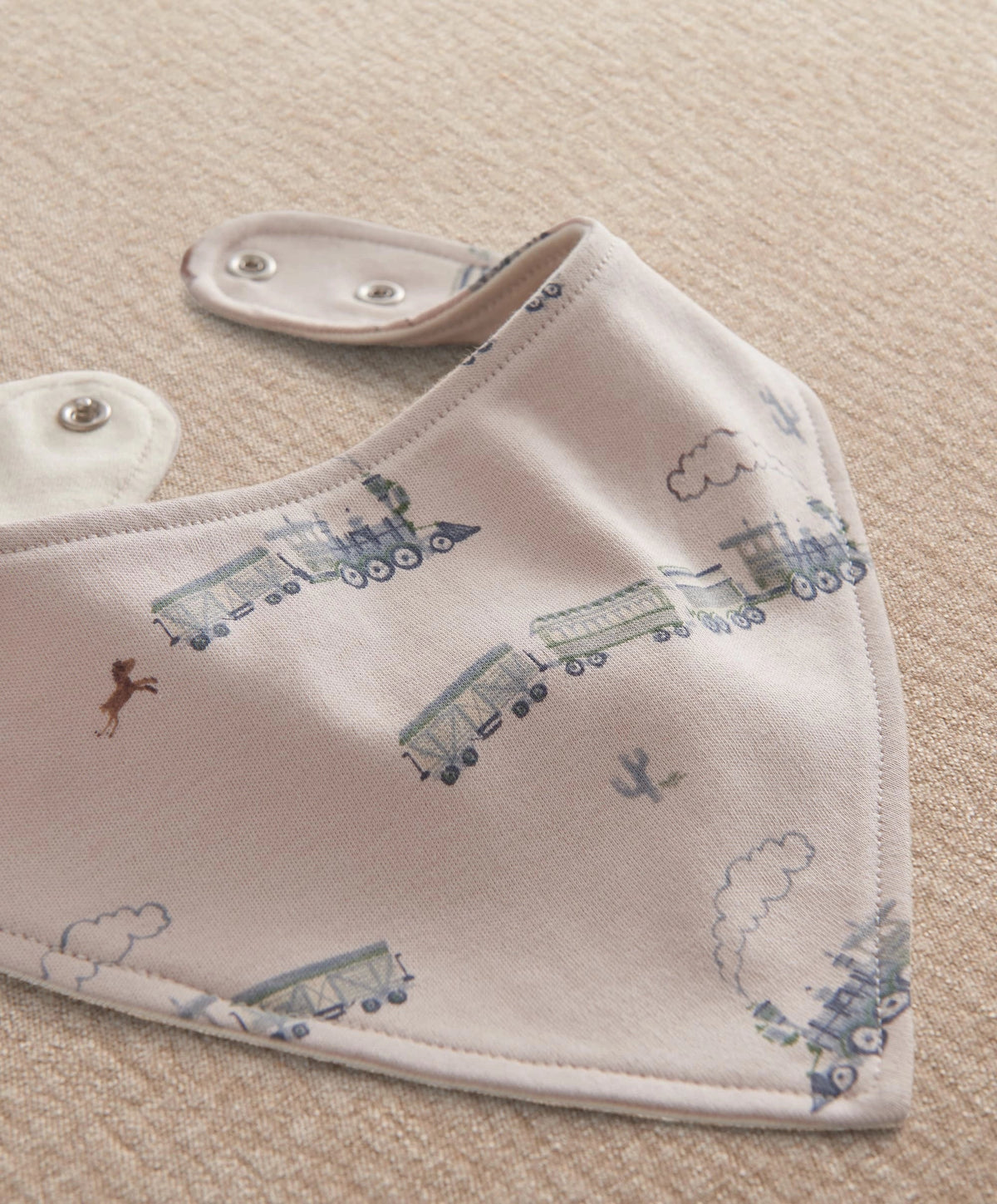 Blue bandana bib with train and cloud print, snap closure
