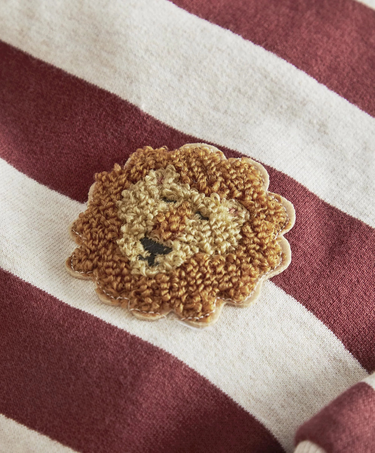 Striped romper with lion appliqué