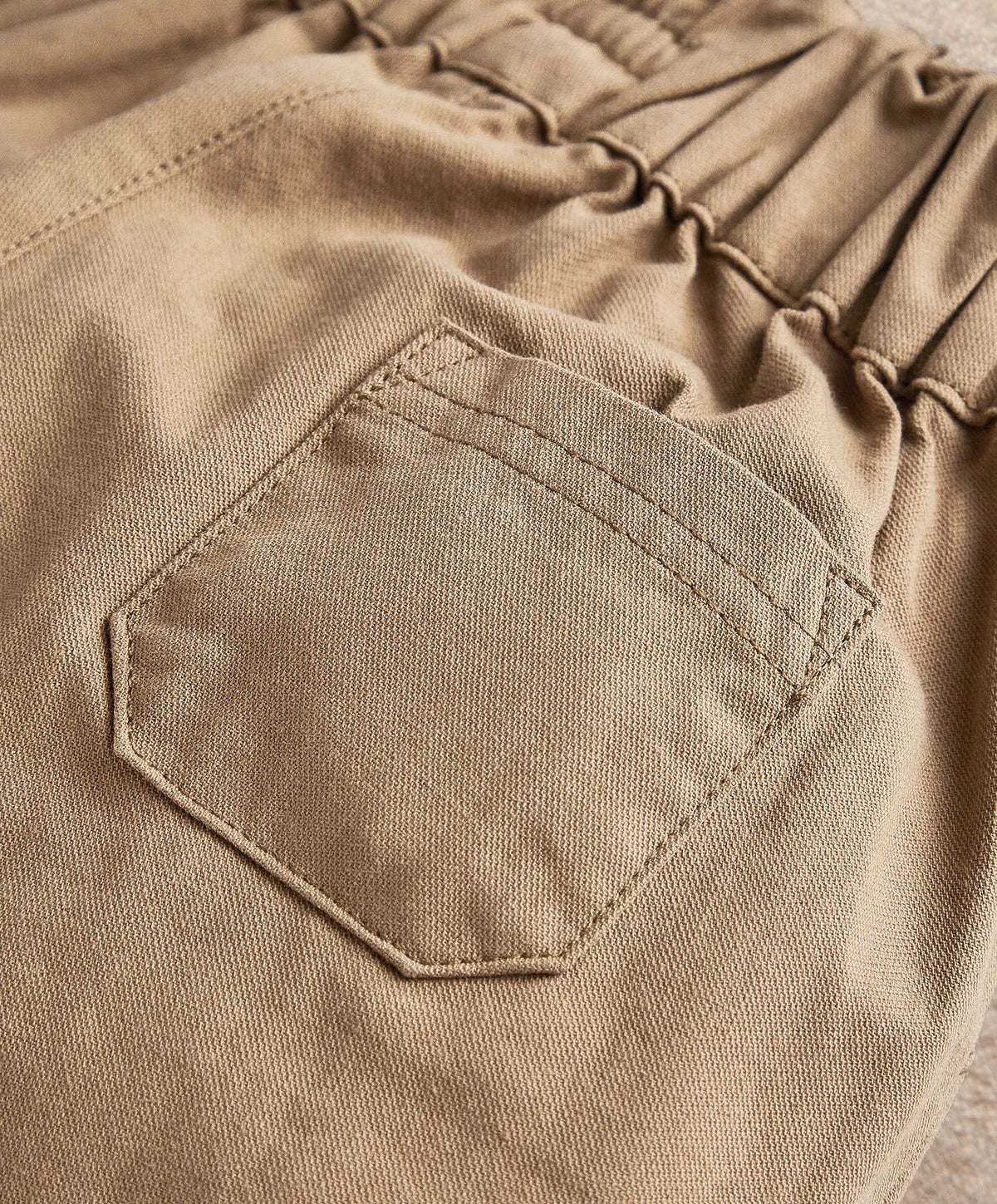 Tan trouser pocket and stitched seam detail on elastic waist