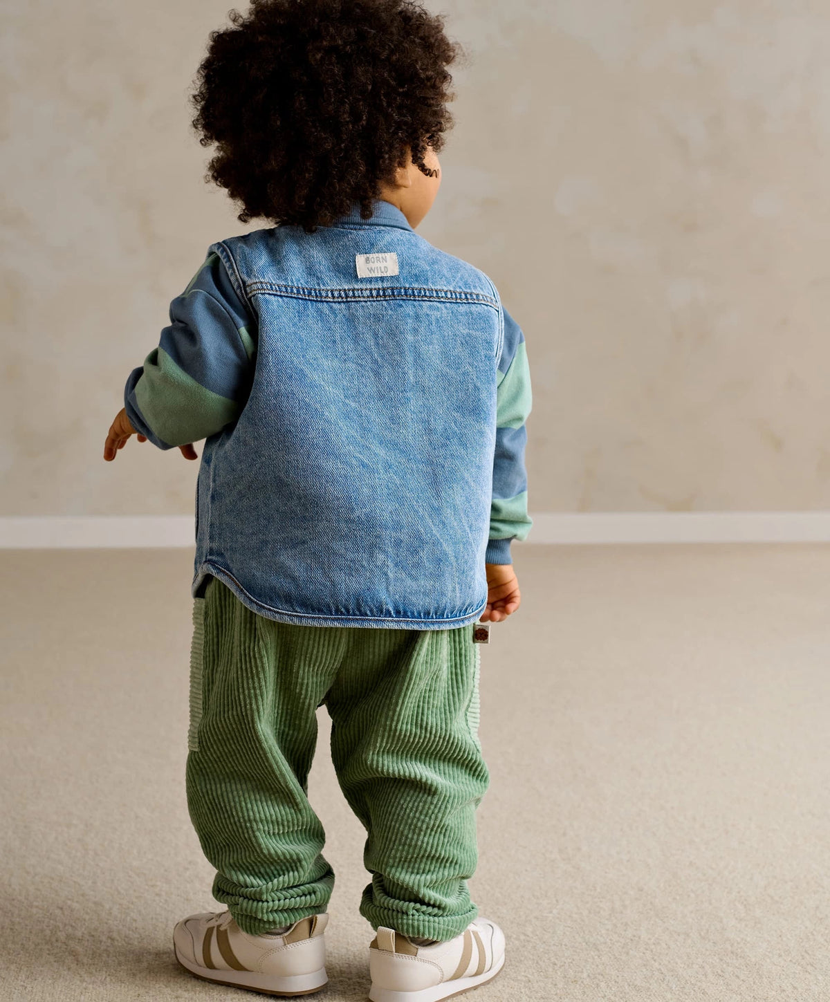 Blue denim sleeveless gilet back view with stand collar and button placket