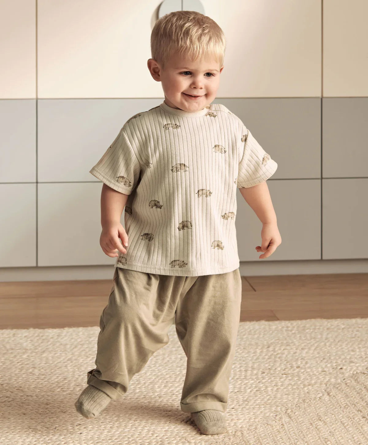 Ribbed t-shirt and trousers set on model, cream rhino print top with olive pants