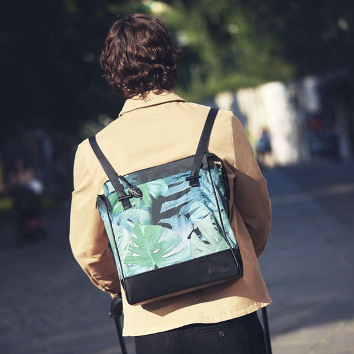 Changing bag worn crossbody, black with green tropical leaf print and side zip pocket
