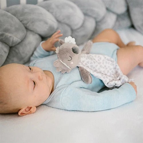 Koala plush comforter held on light blanket, closed-eye gray face