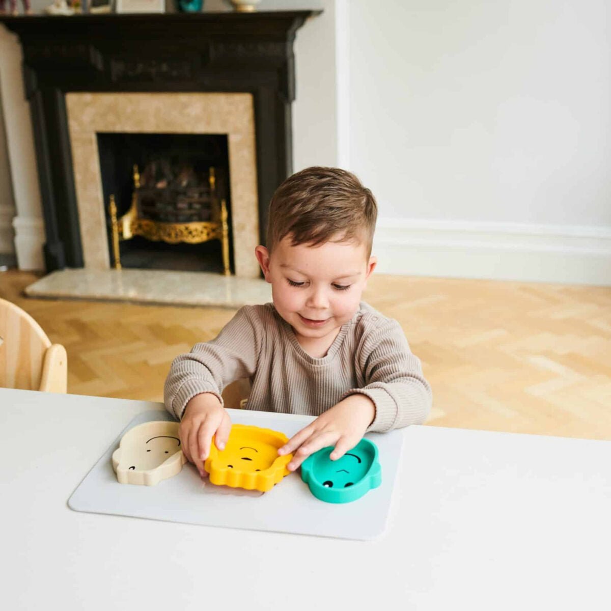 Cool grey animal snack mat with detachable animal pieces on dining table