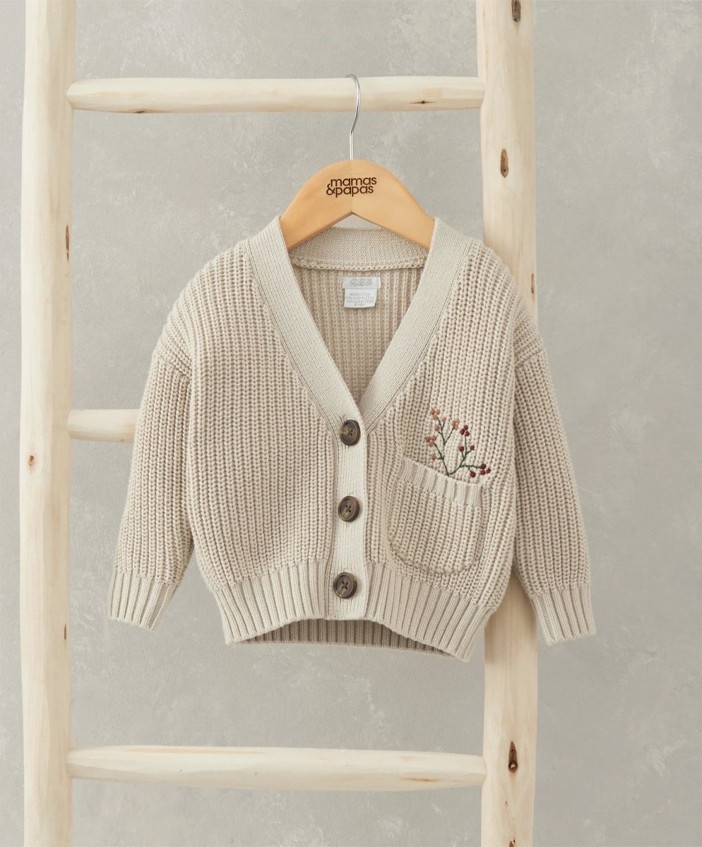 Beige knit cardigan with V-neck, button front, and embroidered chest pocket