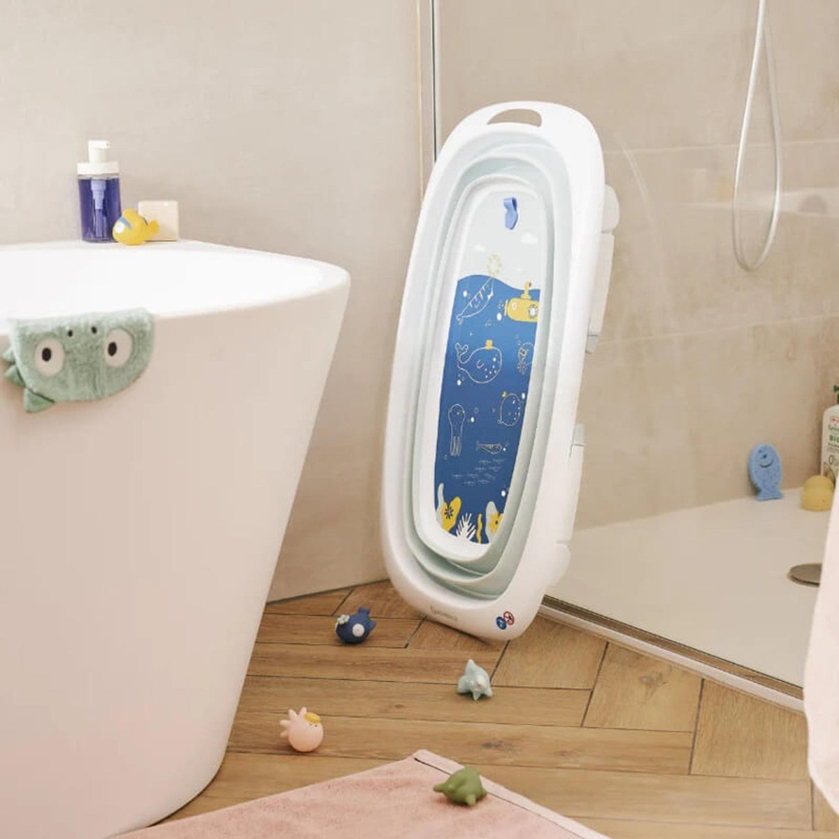 Foldable baby bathtub folded upright with a blue inner panel, white outer shell