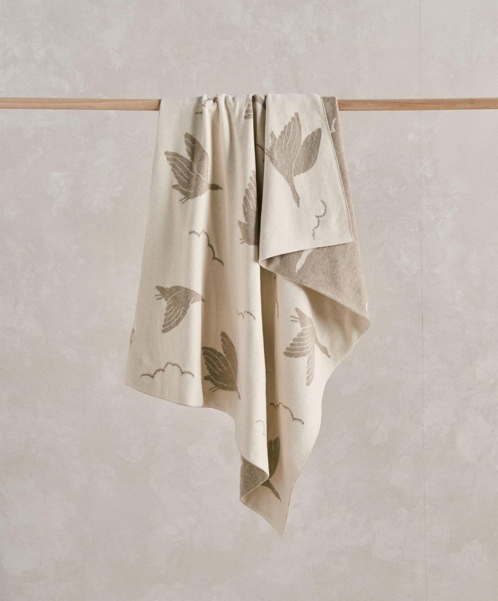 Knitted baby blanket, light mocha beige, duck and leaf print, draped