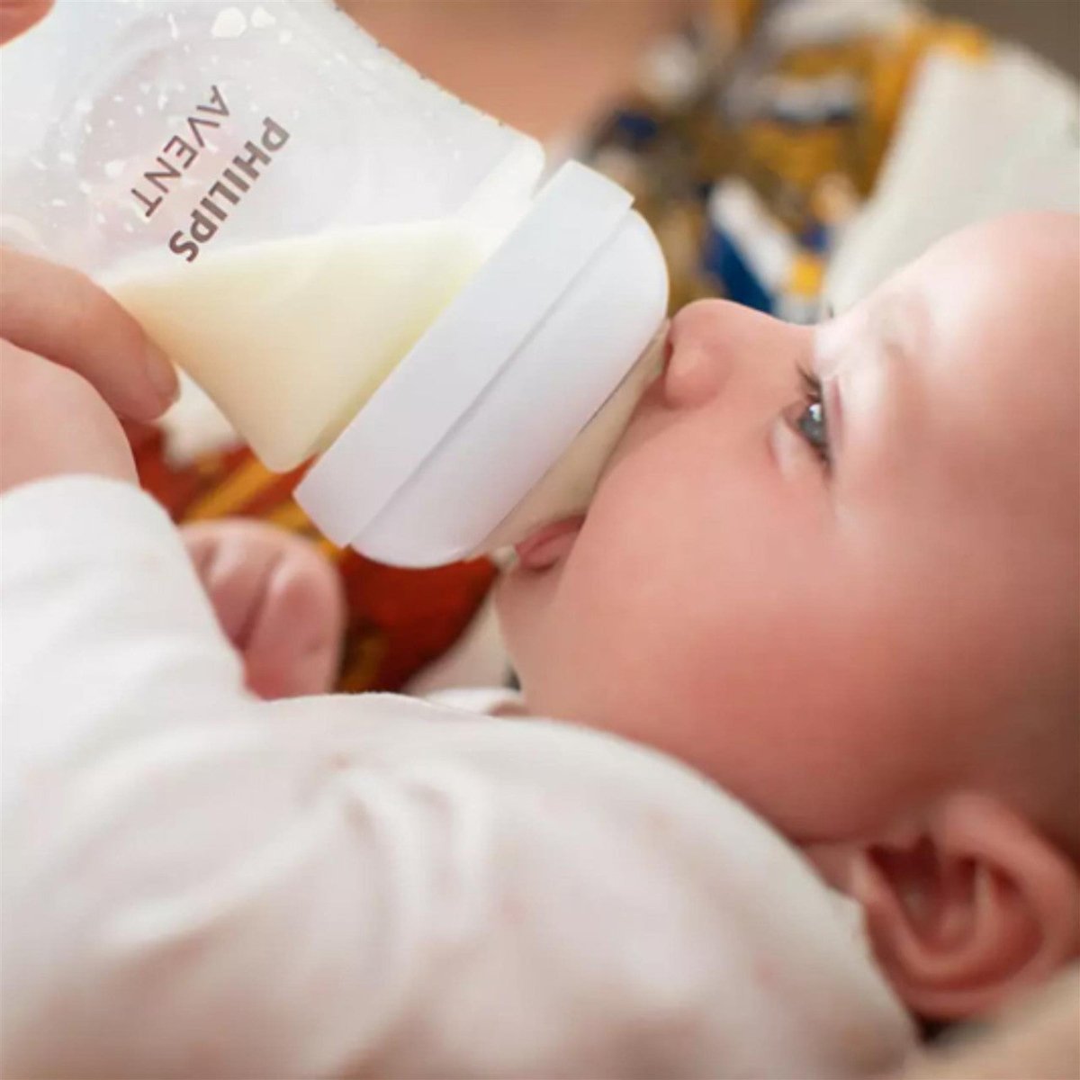 Baby drinking from a bottle with clear teat and soft white rim