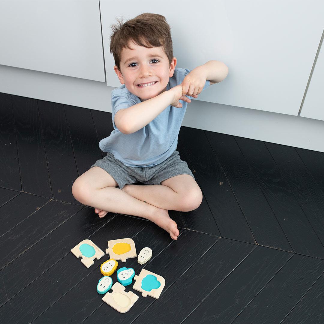 Wooden animal puzzle game pieces with animal faces scattered on floor