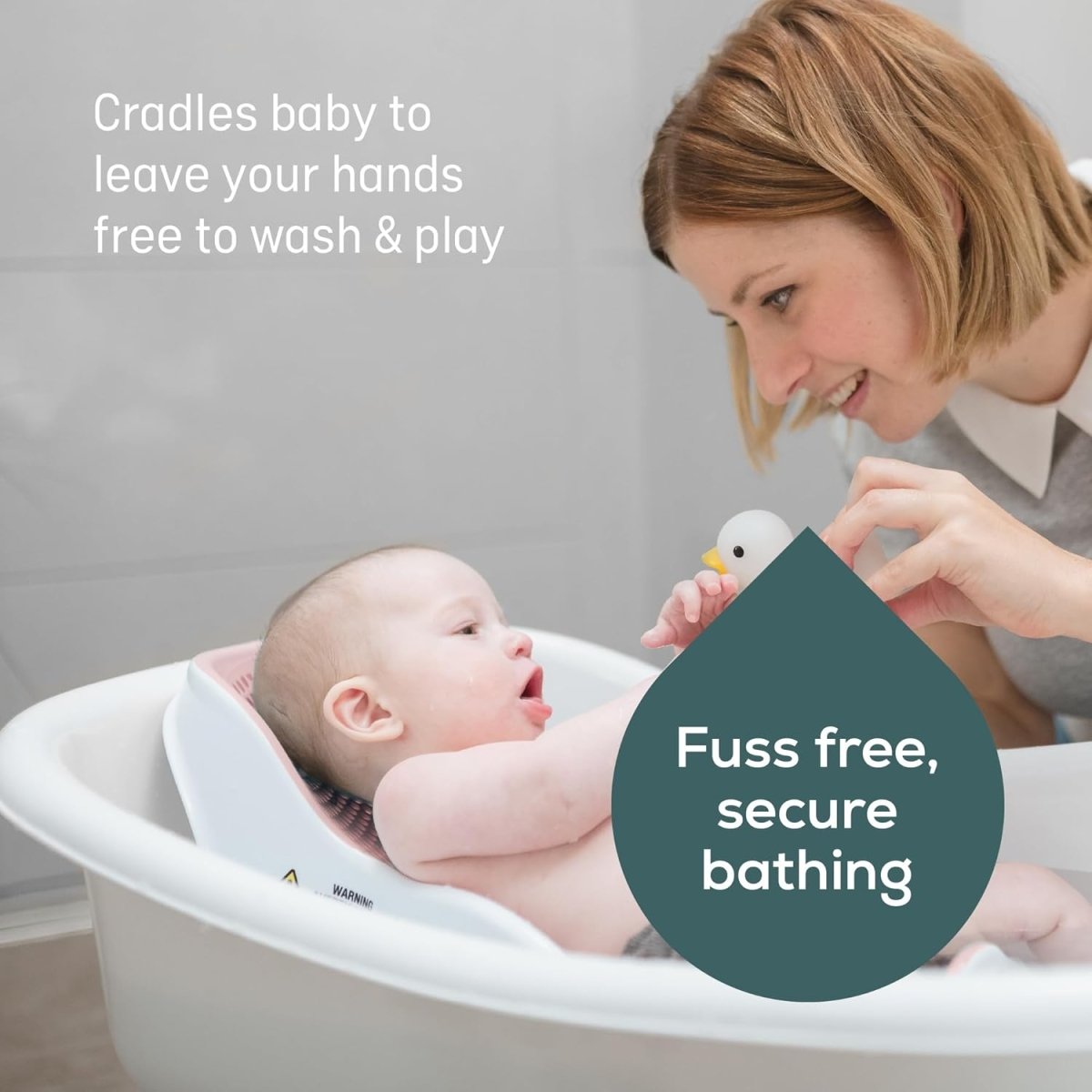 Soft Touch mini baby bath support with newborn reclined, caregiver holding the side