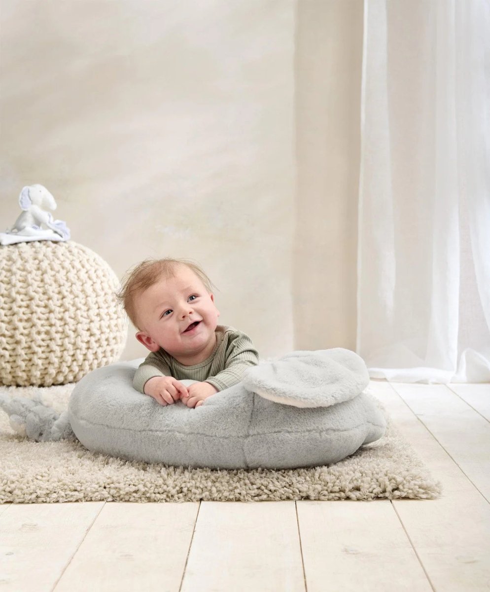 Elephant plush tummy time rug in light gray with cream ears, baby propped on top