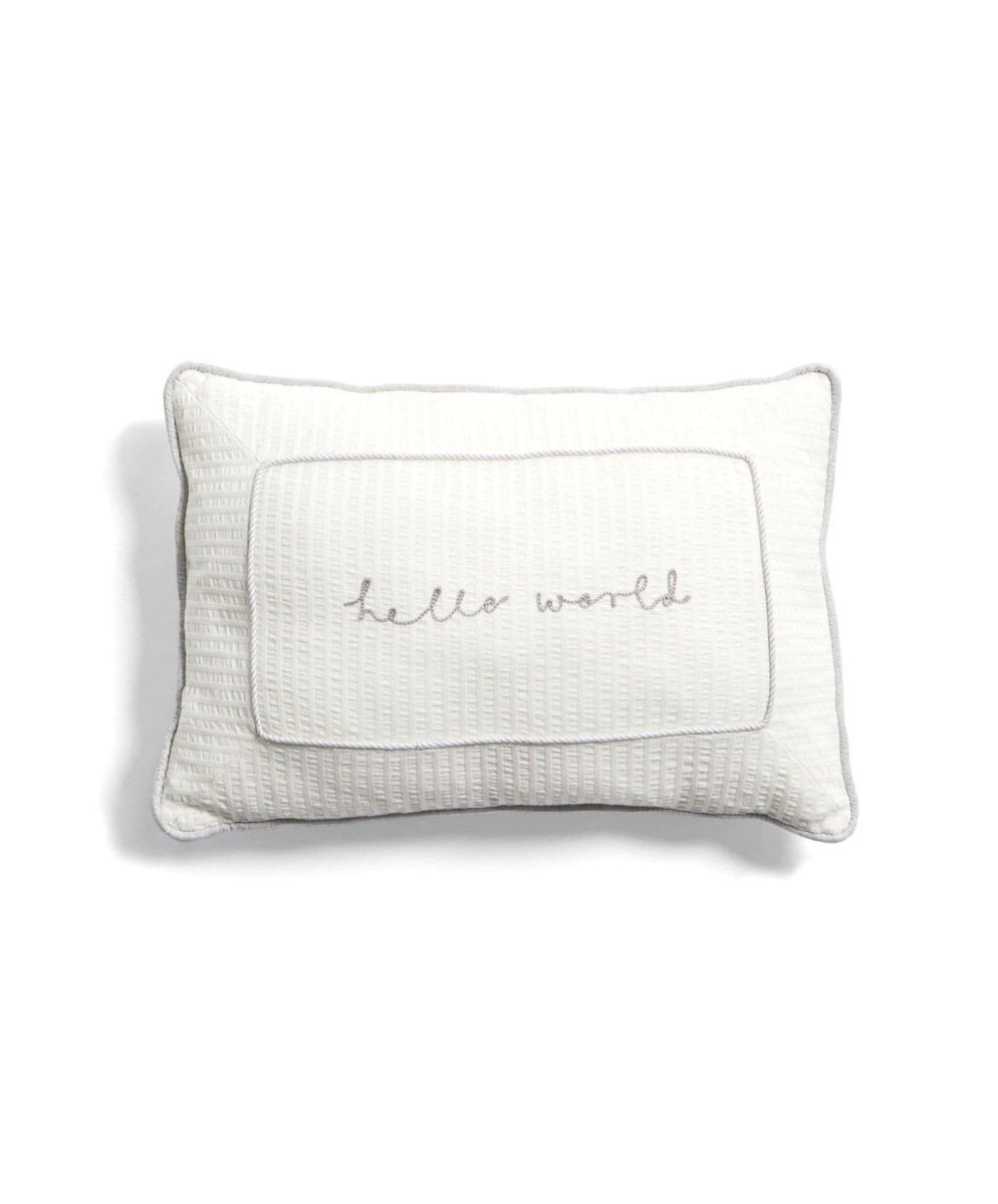 White cushion with quilted border and centered cursive 'world' print
