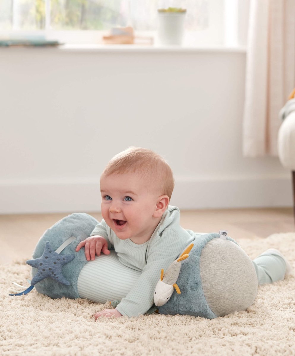 Blue ocean-themed tummy time roll with plush sea animals, used during baby tummy time