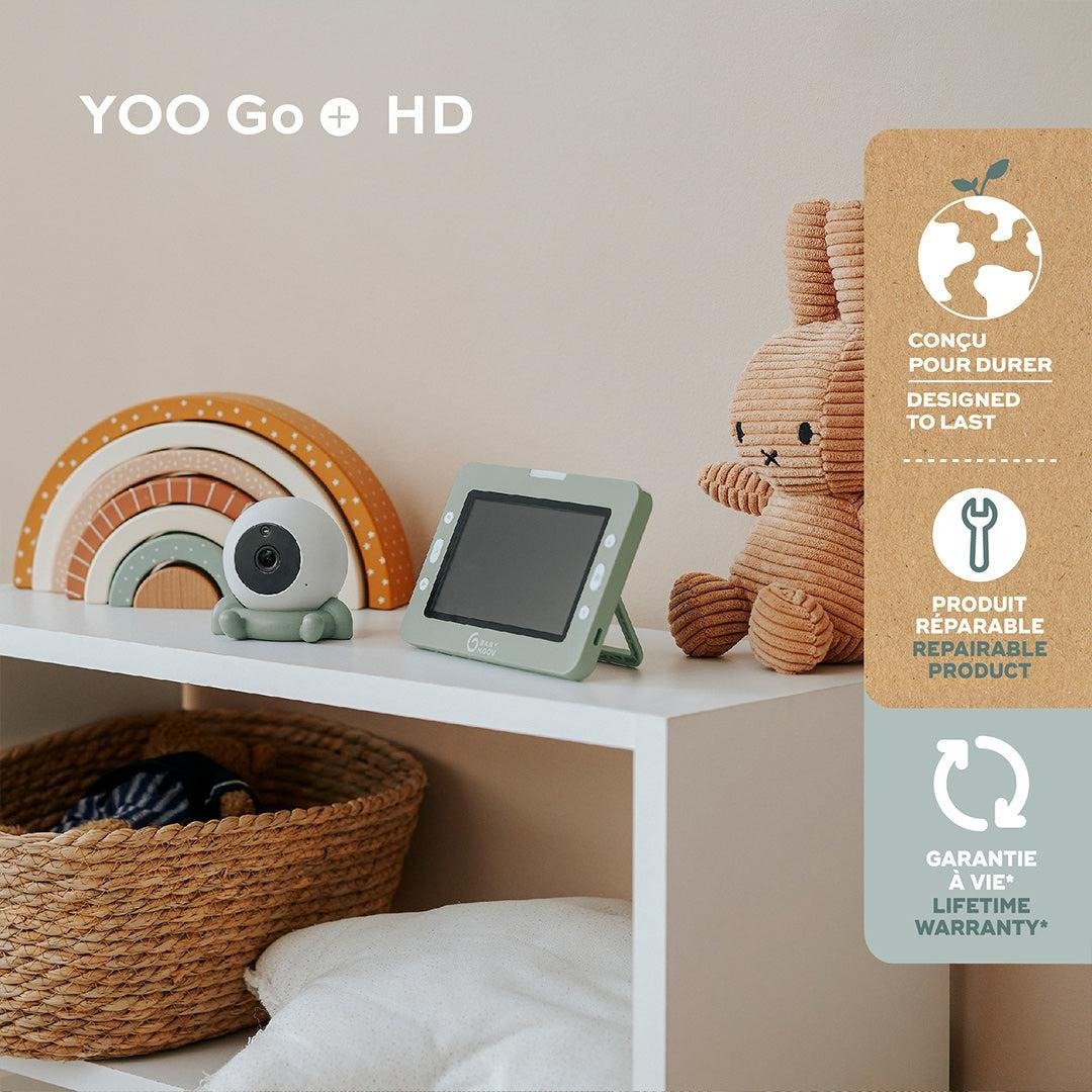 Portable baby monitor on a shelf with green screen and white camera