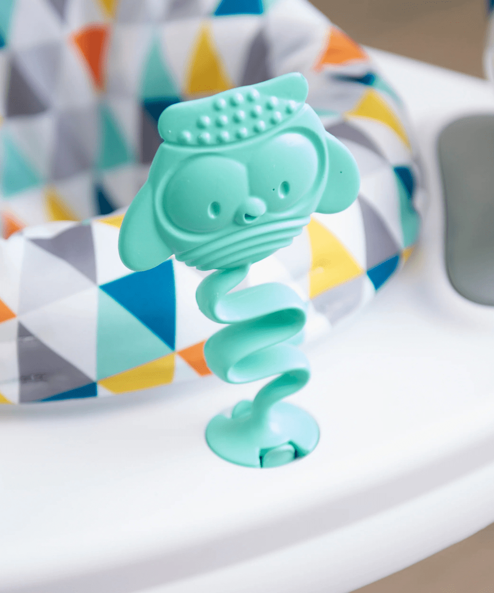 Teal textured creature spring toy on a white activity jumper mat