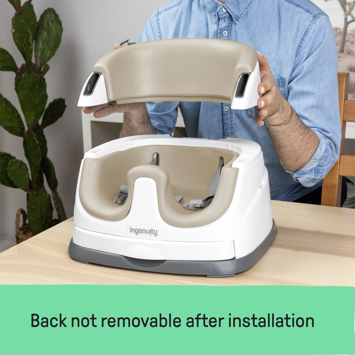 Baby booster feeding seat with beige backrest and white tray, held upright