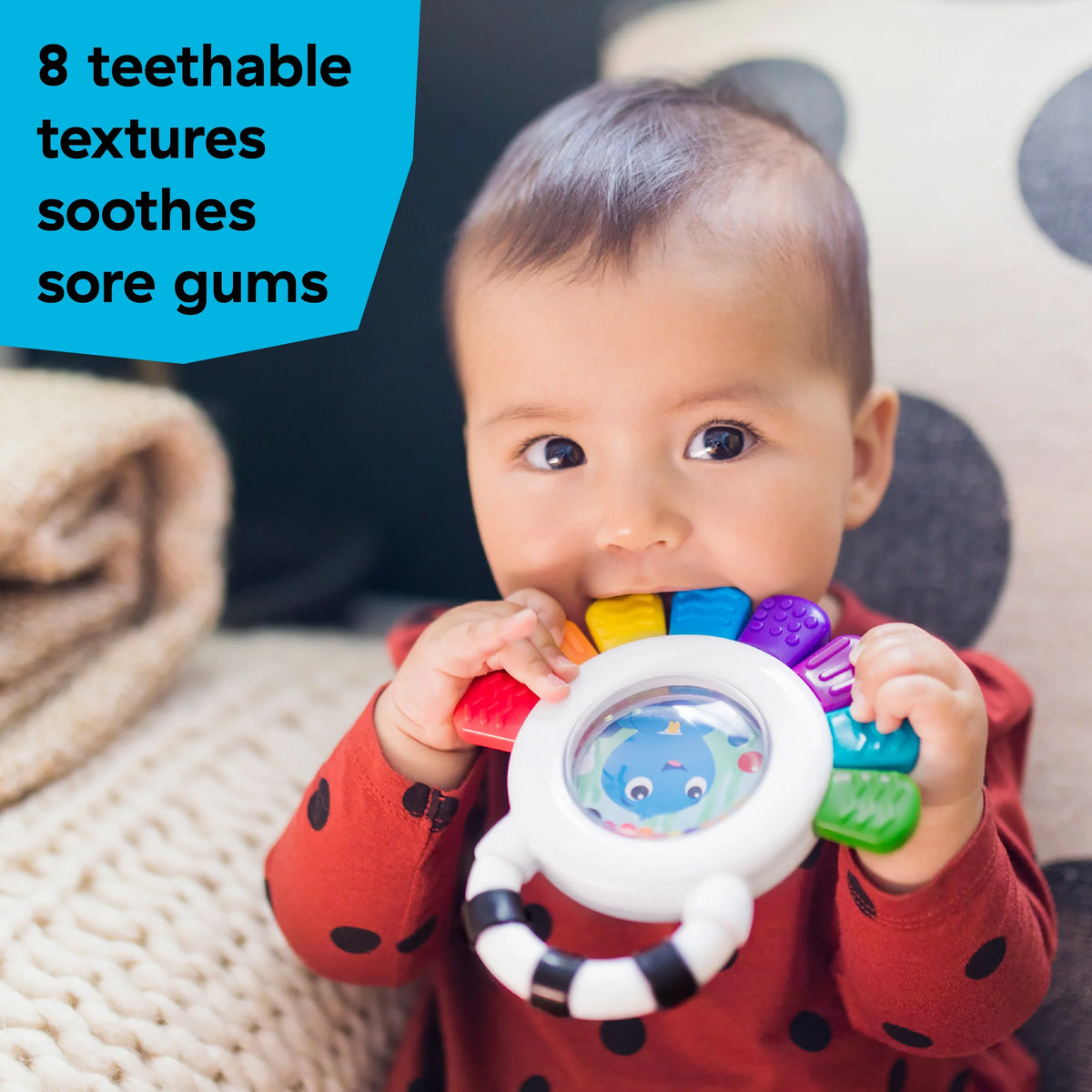 Baby holding octopus rattle and teether toy with rainbow textured rings