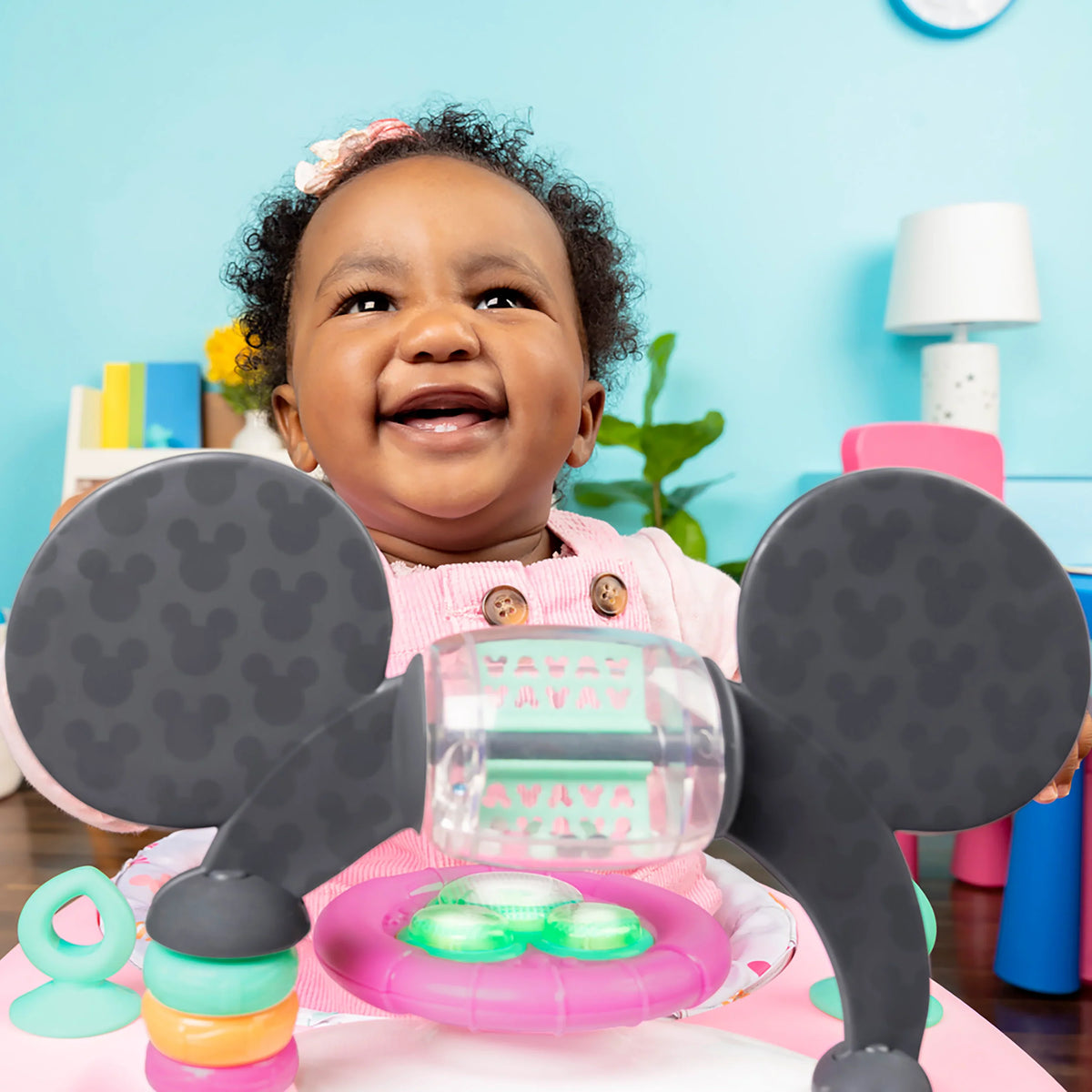 Pink baby walker with Minnie play tray, dark wheels, and front control panel