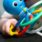 Octopus teether rattle close-up with multicolor plastic grips held in a hand