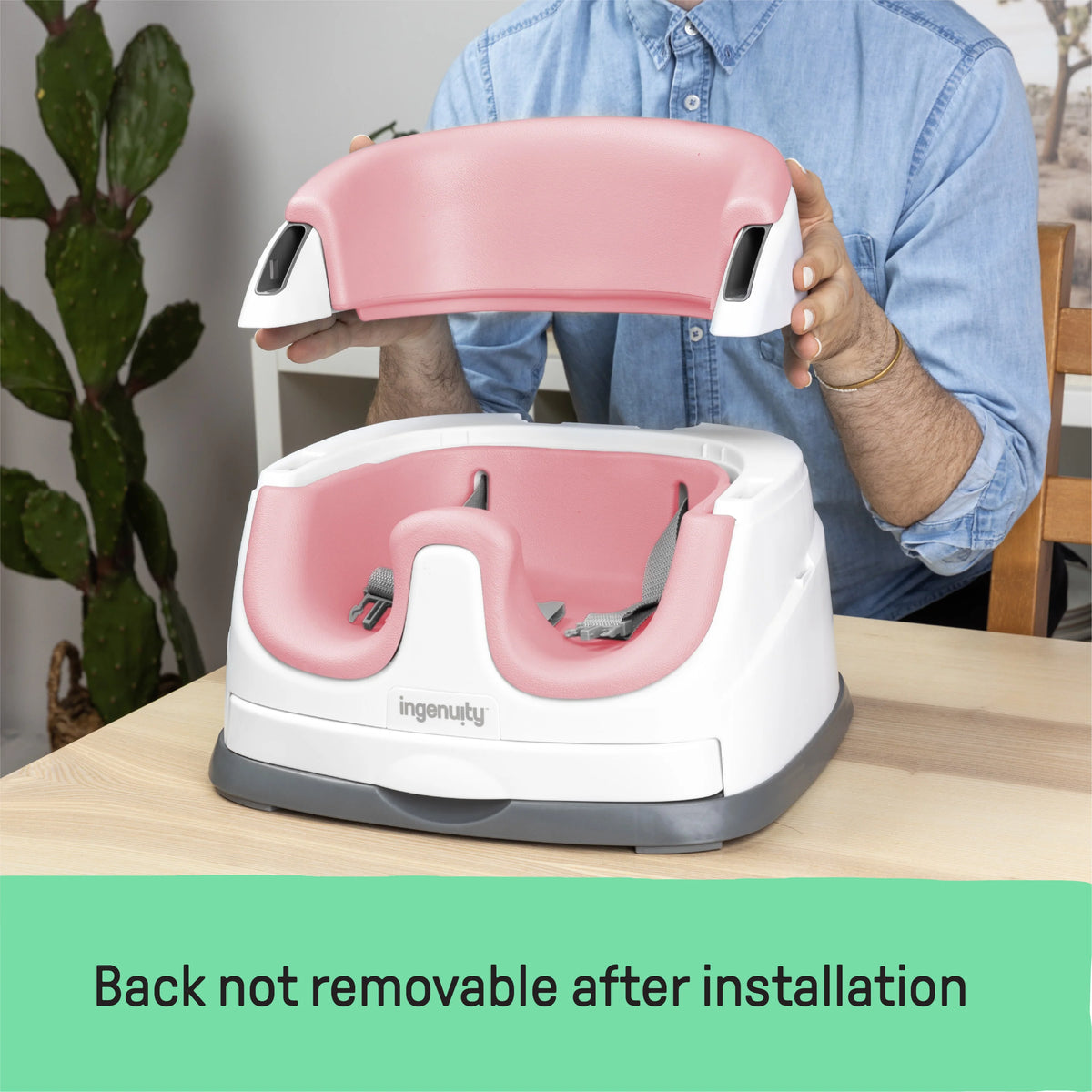 Baby booster feeding seat with pink backrest and white tray, held upright