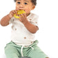 Yellow textured water teether held by a baby in a light outfit