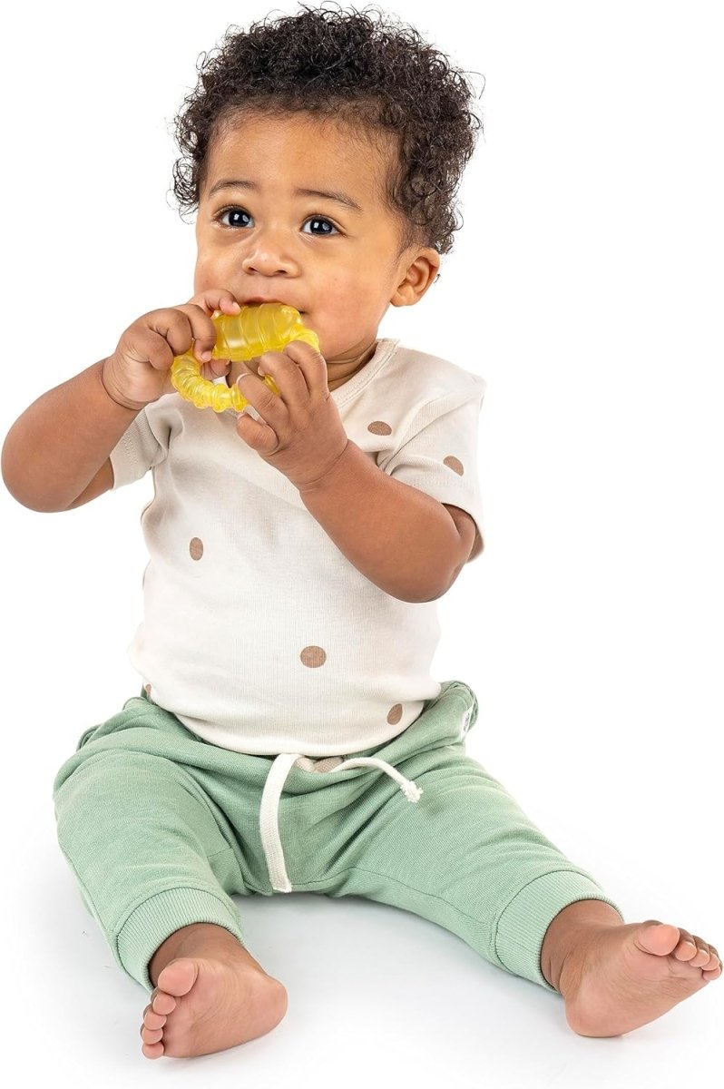 Yellow textured water teether held by a baby in a light outfit