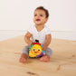 Baby holding a small plush musical take-along star toy with multicolor panels