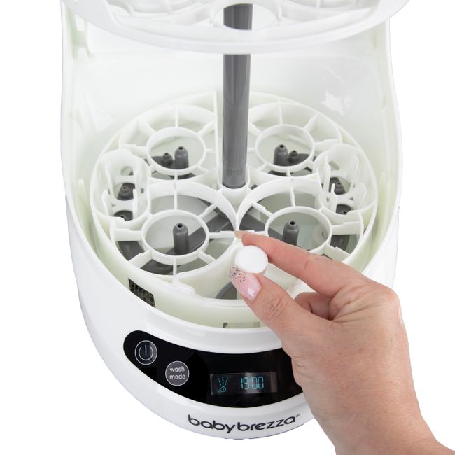 Descaling tablet being placed in bottle washer chamber