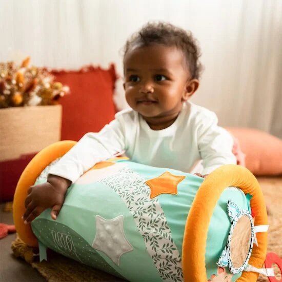 Plush roll-up activity mat on baby, mint fabric with giraffe and star motifs, orange ends