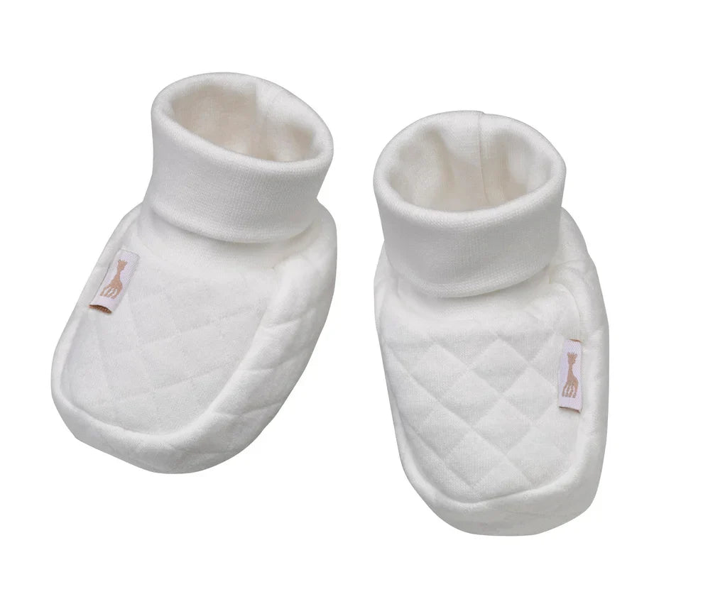 Pair of white newborn booties with quilted texture and fabric applique on sides