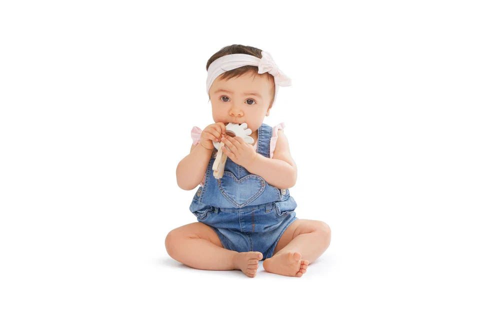 Baby holding white and blue silicone silhouette ring teething toy