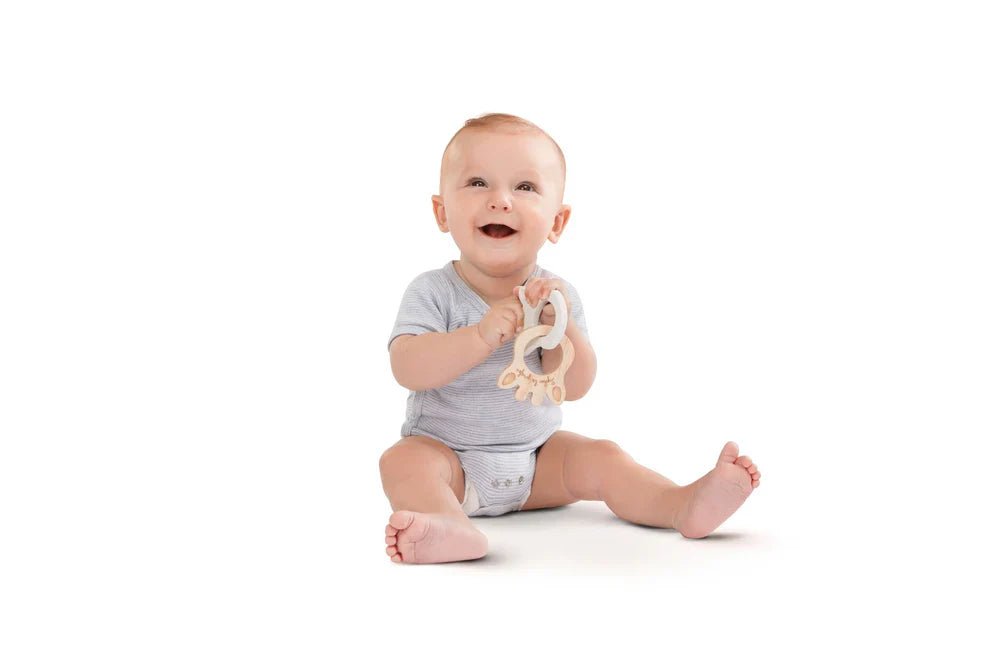 Baby holding natural wood silhouette ring teething toy with cutout handle