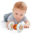 Totem rattle with white plush ends and colorful rings, held in a baby’s hands