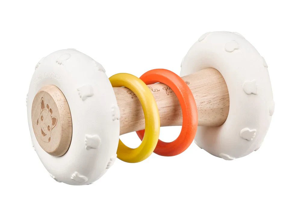 Totem rattle with white plush ends and multicolor plastic rings on light wood handle
