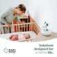 Yoo-Moov video baby monitor on bedside table with white body and blue lens ring