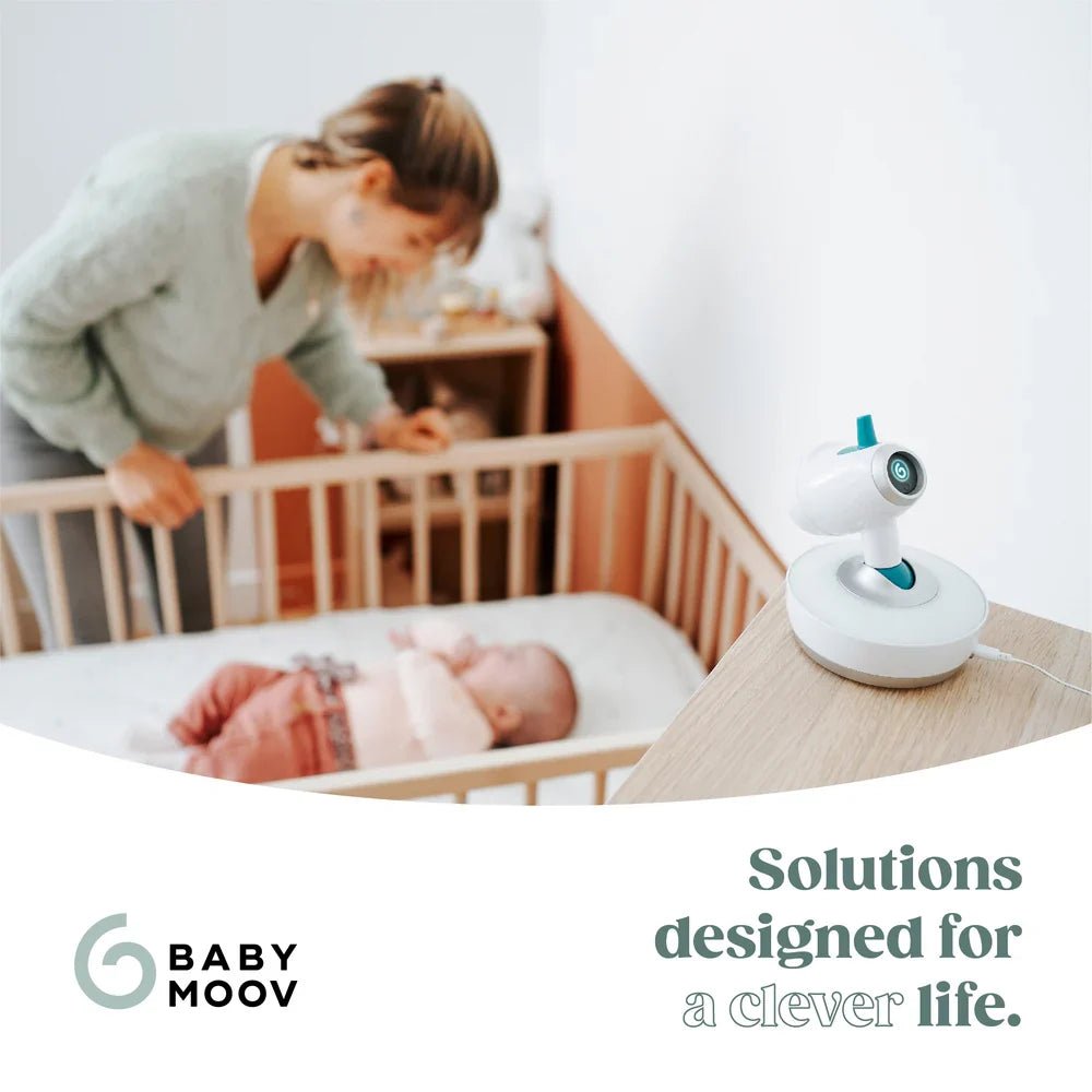 Yoo-Moov video baby monitor on bedside table with white body and blue lens ring