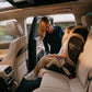 i-Size car seat with harness and padded sides, child seated beside adult