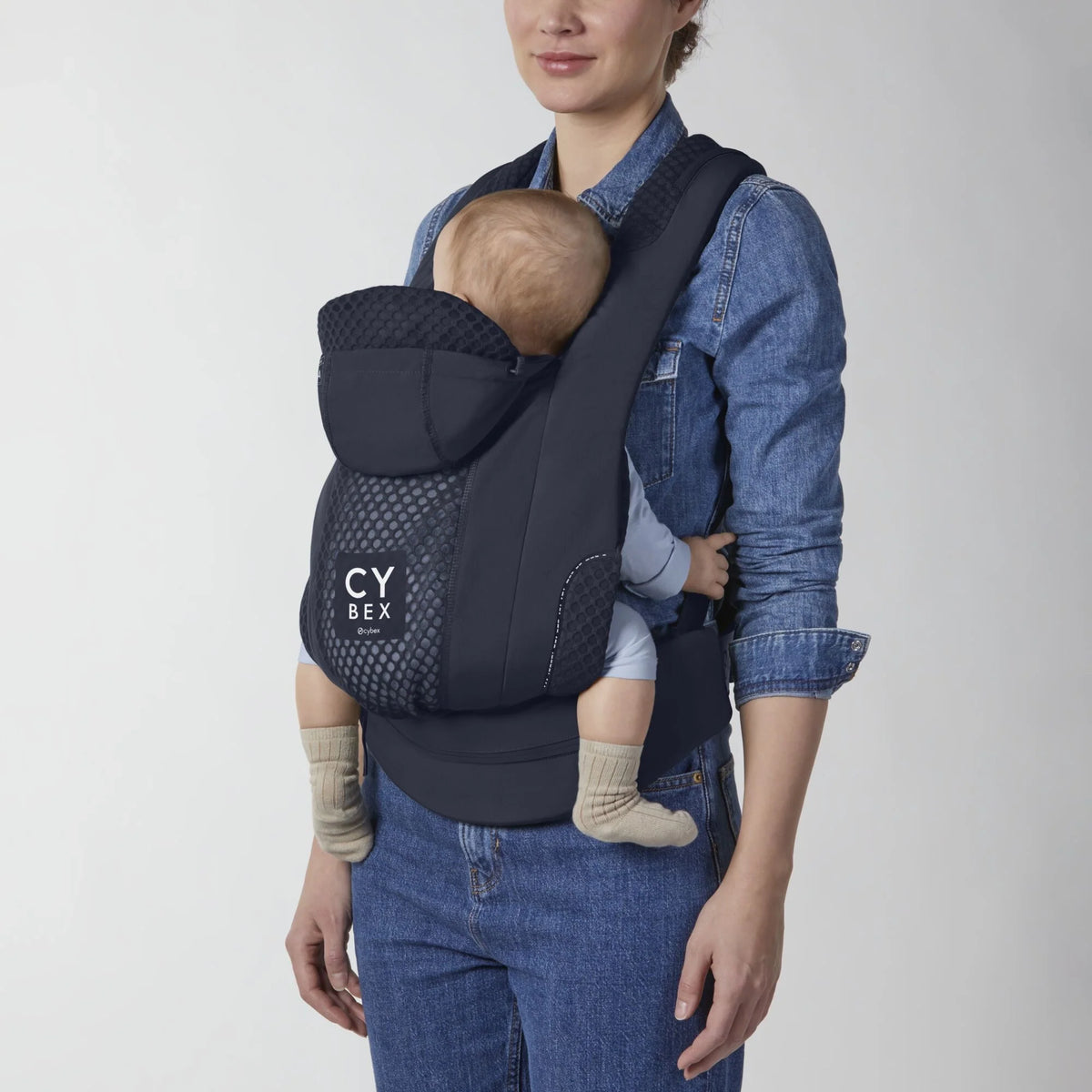 Dark blue baby carrier worn on model, front pocket and CY BEX logo visible