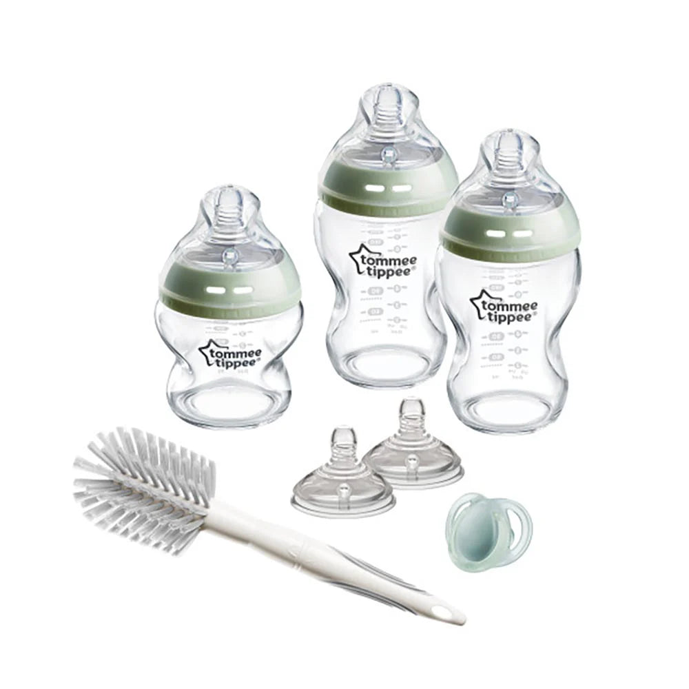 Glass newborn bottles with green silicone collars, teats, and cleaning brush