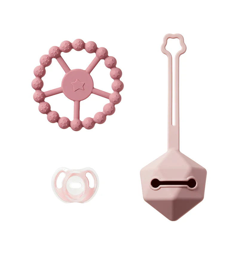 Pink silicone teether ring with star center, pacifier and handled cleaning brush
