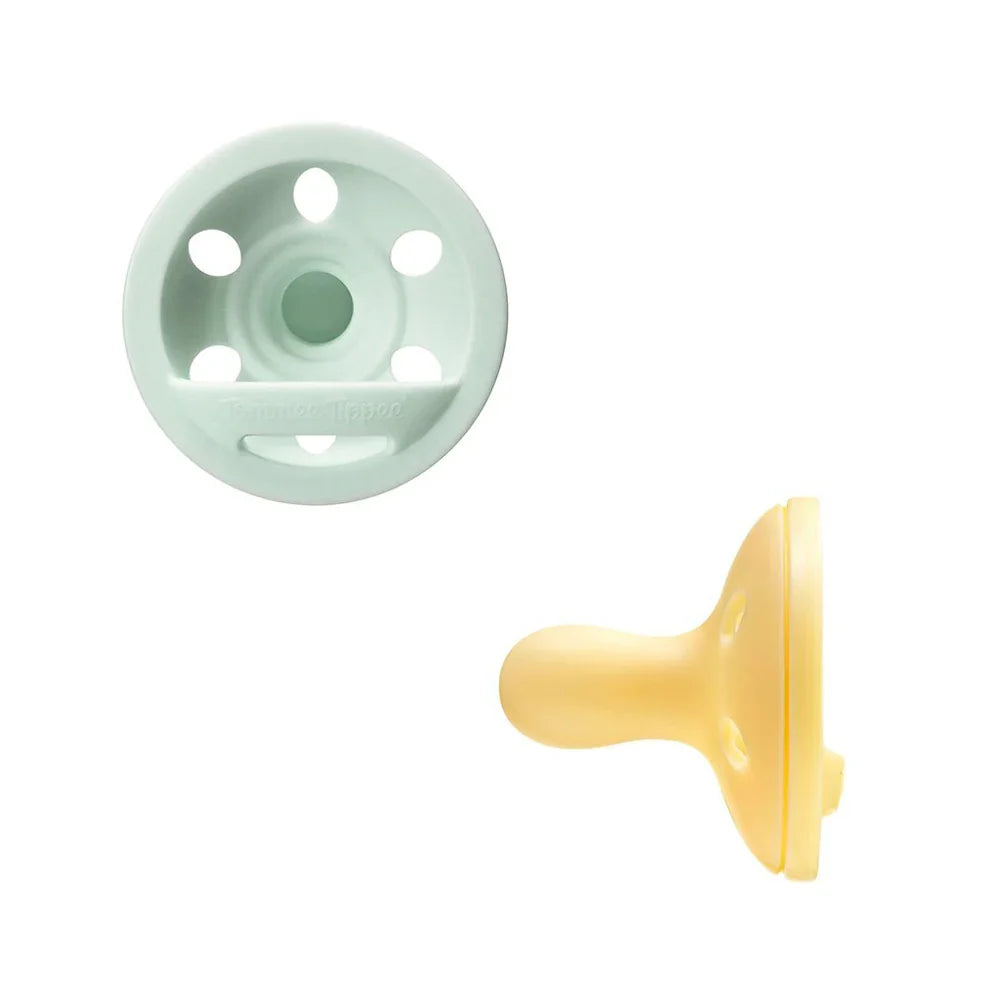 Breast-like pacifier pair, mint green shield with holes and yellow pacifier tip.