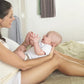 Nursing cover pads in use while breastfeeding, caregiver holding baby on couch