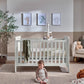 Nimbus White cotbed with vertical slat sides and guard rail, front view.