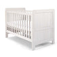 White wood cotbed with vertical slats and two padded end panels, open side