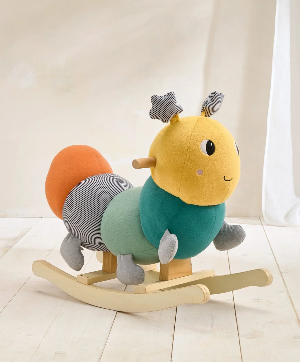Stuffed rocking caterpillar toy with yellow face, teal body, striped ears and legs
