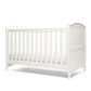 White cotbed with vertical rail sides and arched end panels.