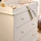 White dresser changer close-up with three drawers, knob pulls, and raised top
